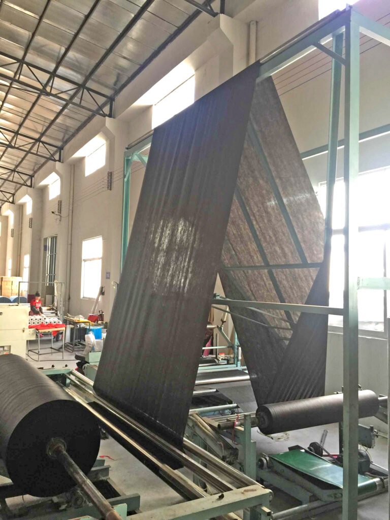 In the production workshop for small rolls of black weed-control non-woven fabric, the manufacturing equipment is operating at high speed, delivering massive production capacity.