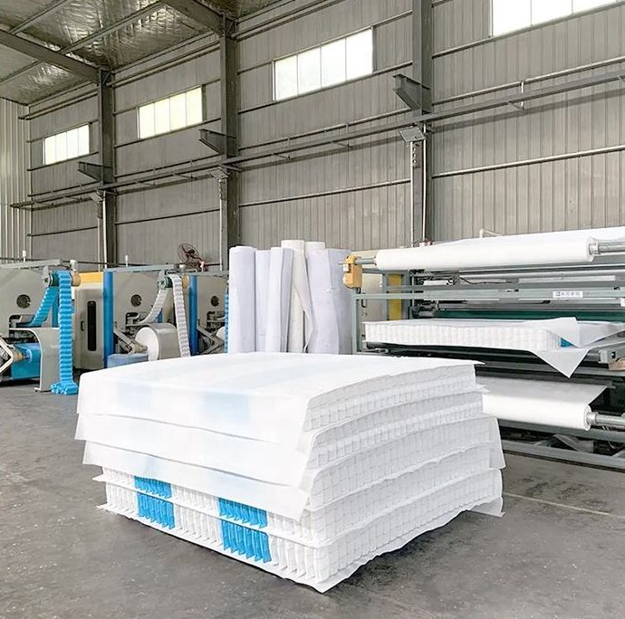 Inside a Chinese mattress independent pocket spring assembly workshop, pocket springs are rapidly being assembled into spring units, with every spring encased in white furniture-grade non-woven fabric.