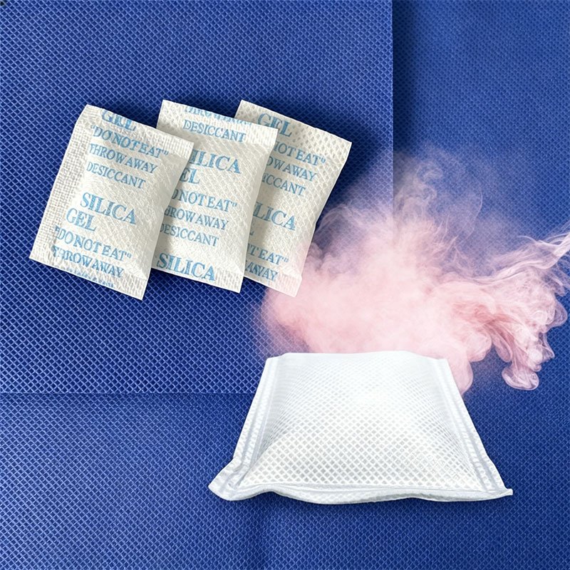 Three silica gel desiccant sachets and one heating packet made from PET spunbond nonwoven fabric laid on blue nonwoven background
