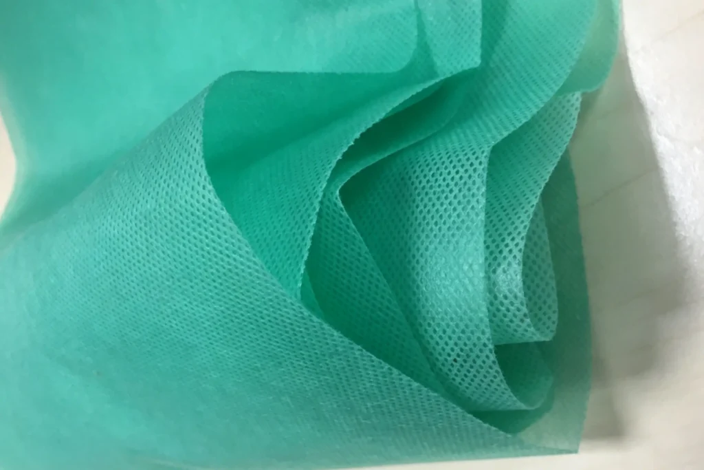 close-up texture of Takewind green geotextile fabric, pure virgin polypropylene nonwoven with neat dot mesh