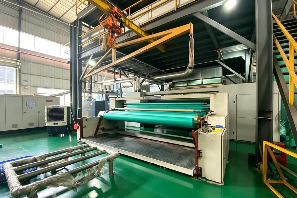 Large hot pressing calender machine processing green geotextile rolls in standardized geotextile production workshop