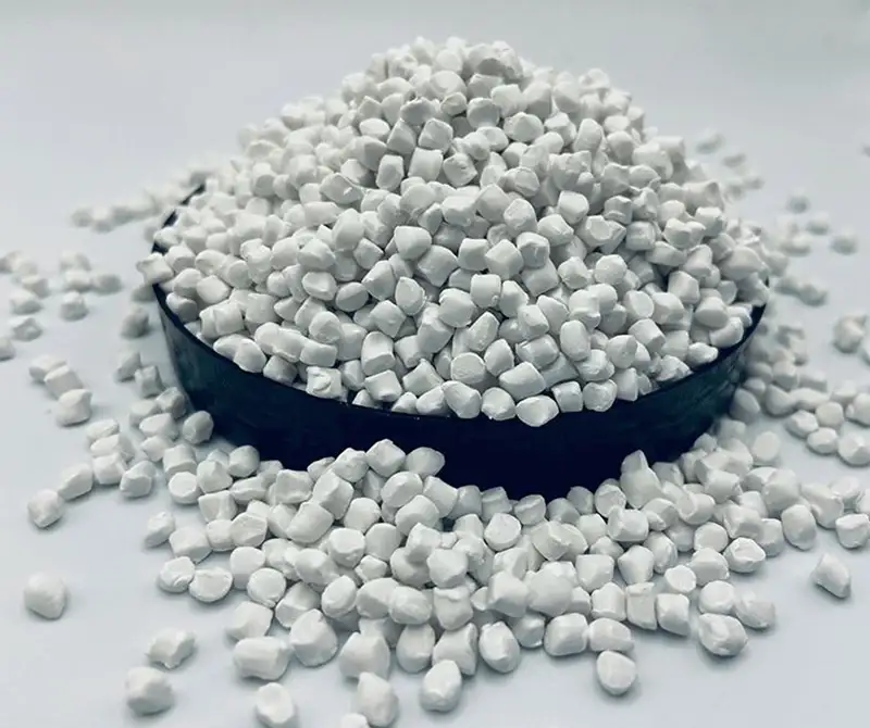 White calcium carbonate filled masterbatch pellets, filling modifier raw material for PP spunbond nonwoven, piled granules in black bowl on light gray background