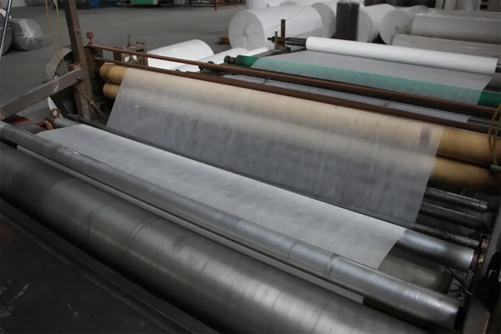 Running production rollers manufacturing thin permeable nonwoven geotextile fabric with uniform fiber distribution