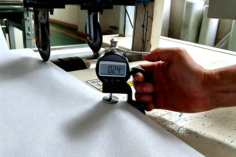 Digital thickness gauge testing 0.24mm thickness of white mesh PP spunbond nonwoven fabric, Takewind factory precise physical inspection