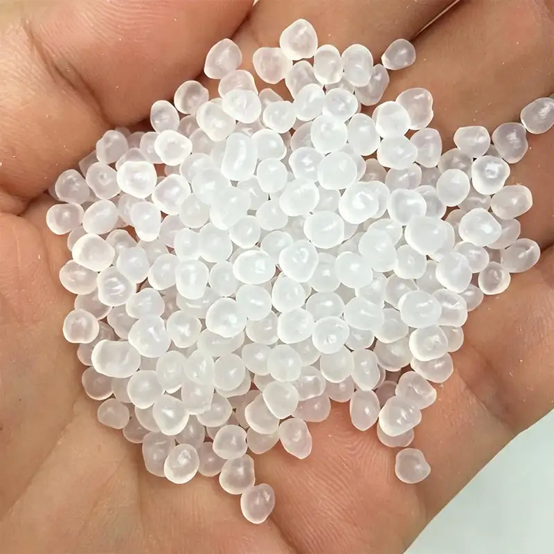 Hand holding translucent pure virgin PP resin pellets, raw material for Takewind green nonwoven geotextile fabric, food-grade new polypropylene granules