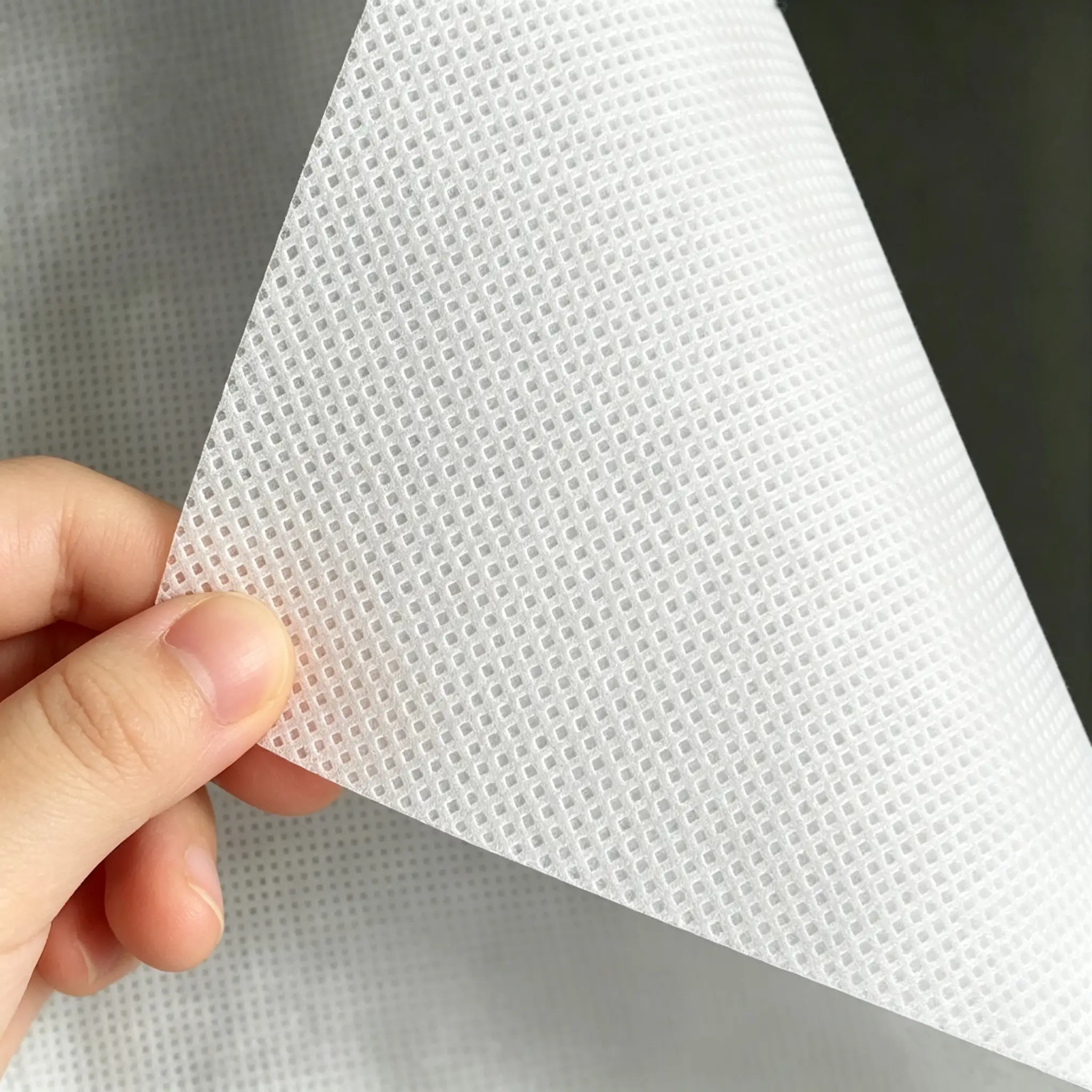 White PP spunbond nonwoven fabric interlining held by hand, Takewind nonwoven for clothing, shoes and luggage lining