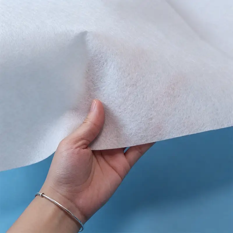 Hand holding white takewind needle punched non woven fabric, show fluffy fiber texture