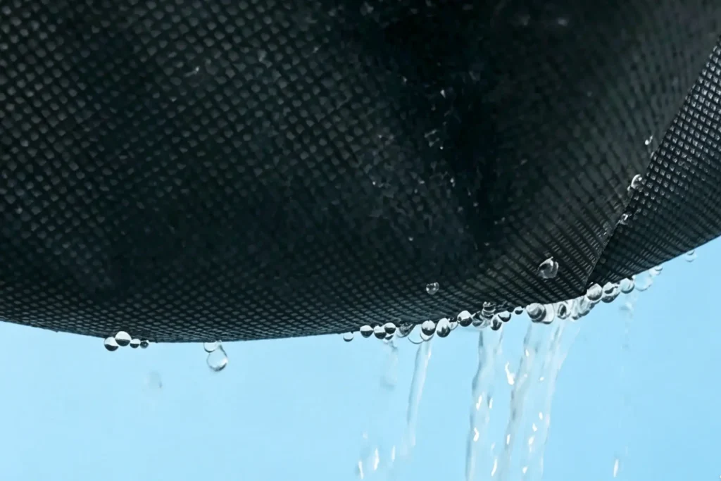 Hydrophilic black weed barrier non woven fabric showing water permeation, water passes through garden non woven textile